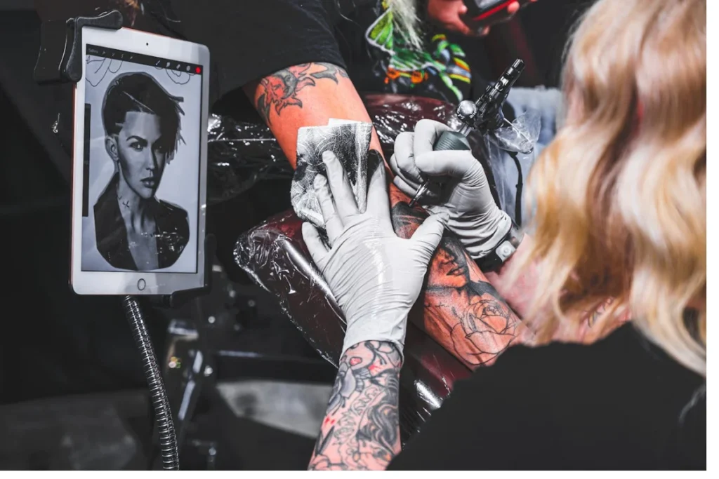 Woman is tattooing an arm