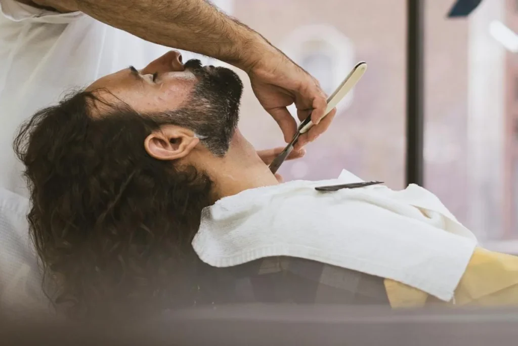 Man sits in a chair in a barbershop