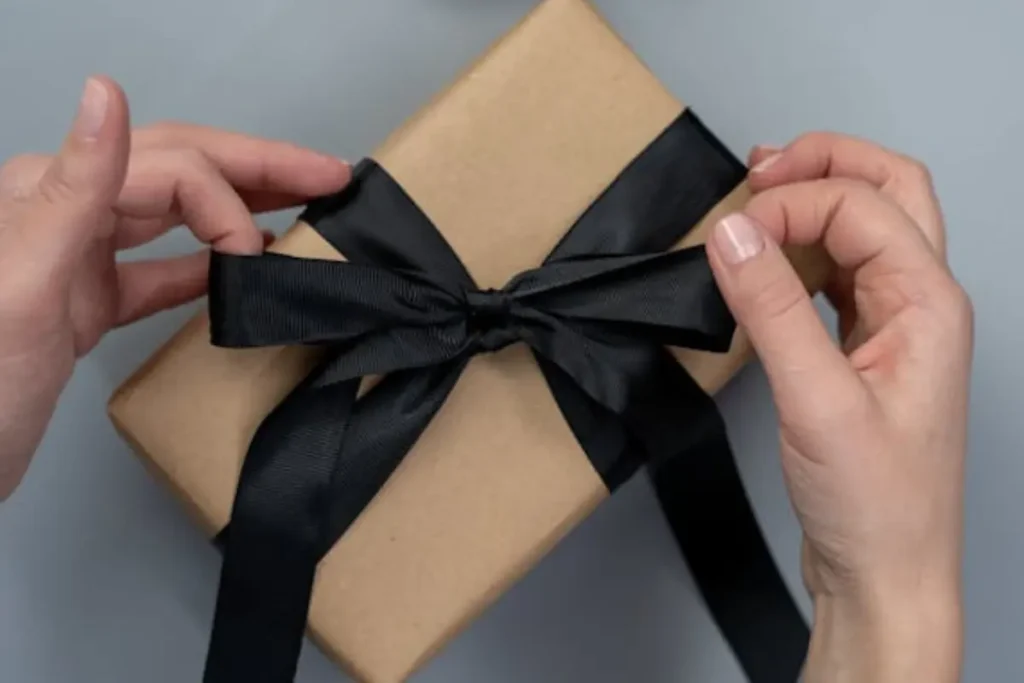 woman's hands tightening the ribbon of a present
