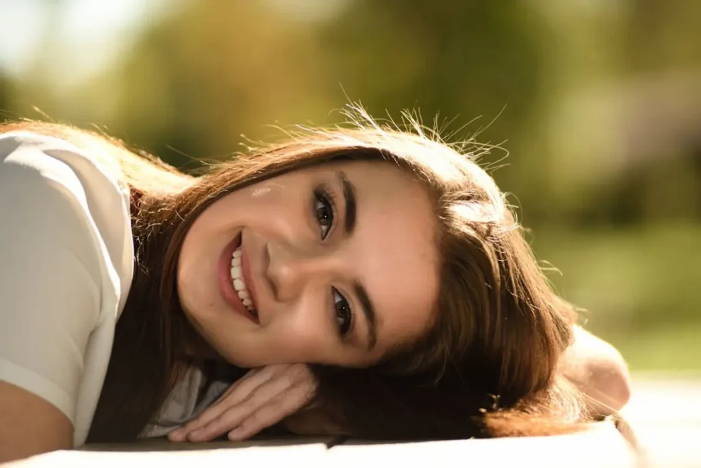 The smiling face of a reclining woman