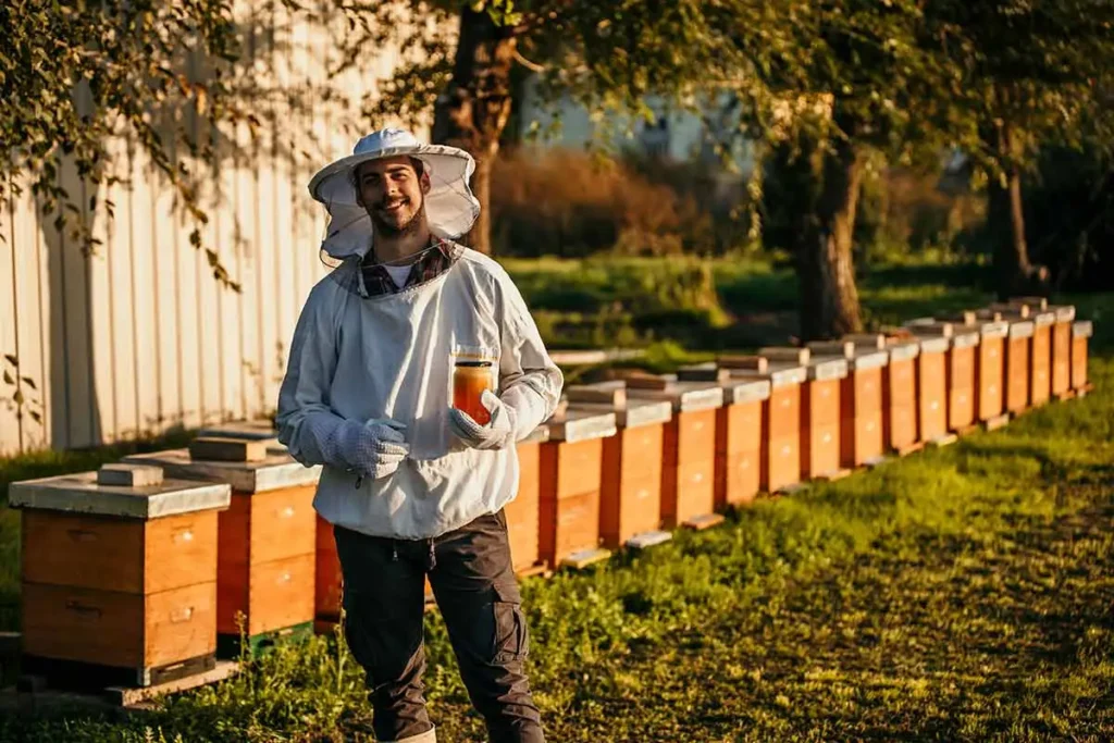 a beekeeper holding a jar of honey