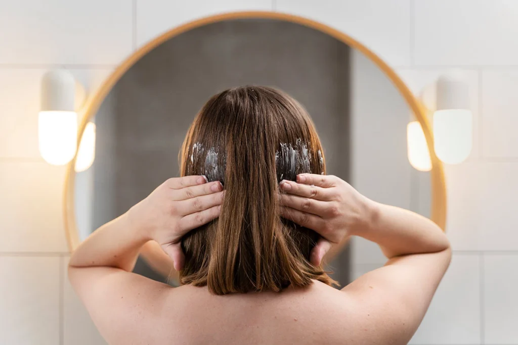 a woman on her back applying Sweet Comb Chicago’s Bee Slick Hair Pomade to her hair