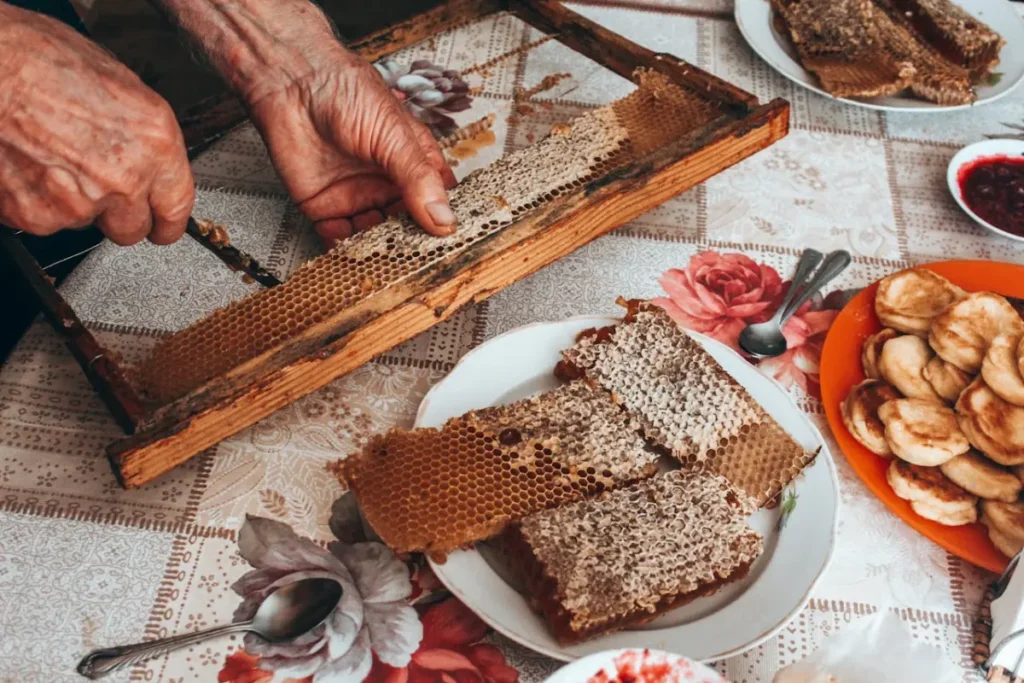a man pulling out pieces of honeycomb to eat for breakfast. Bee Pollen health benefits