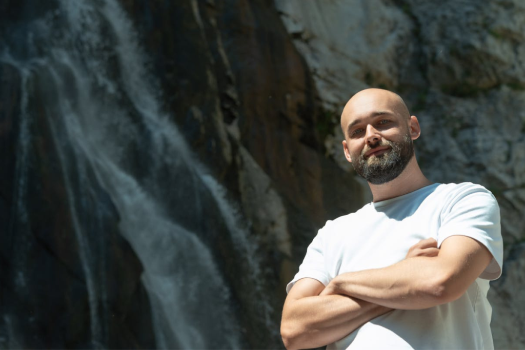 bald man with beard and crossed arms. How to keep a bald head healthy and shiny