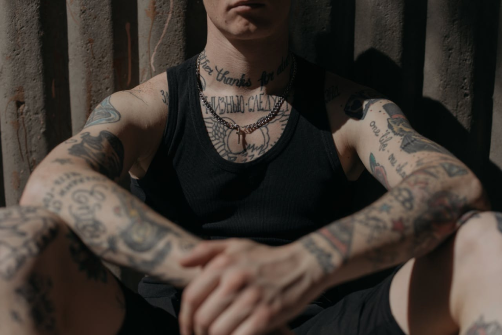 Seated man with several tattoos