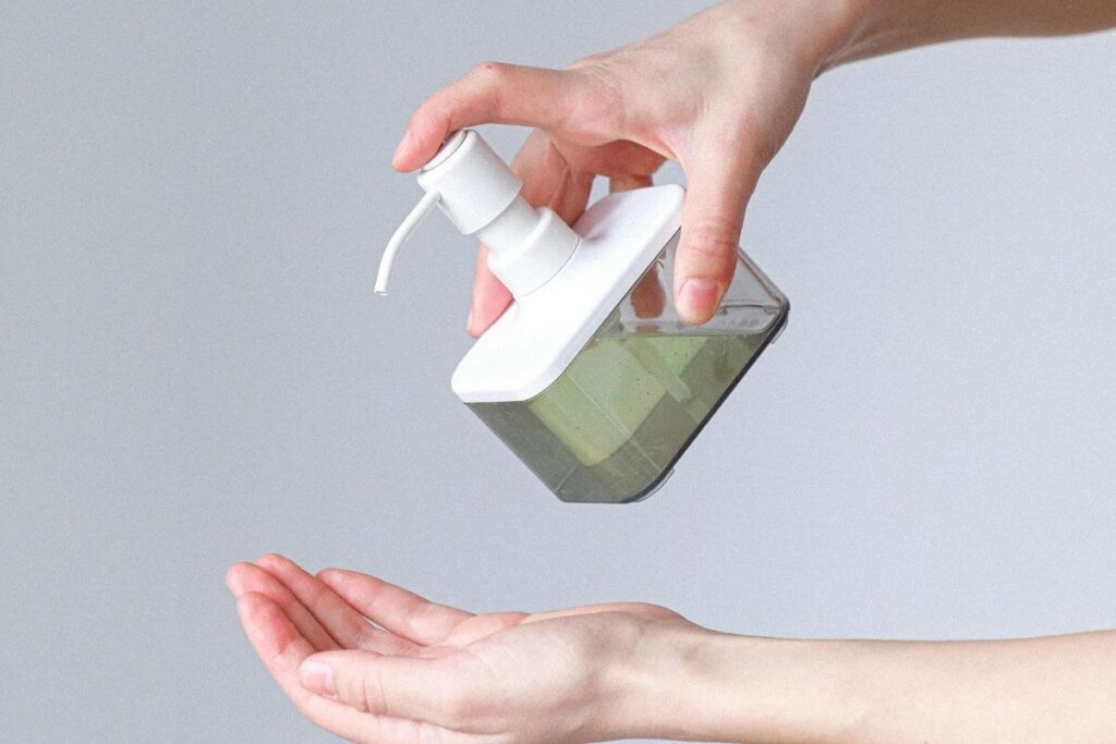transition from antibacterial to natural hand soap. Hands with a bottle of liquid hand soap
